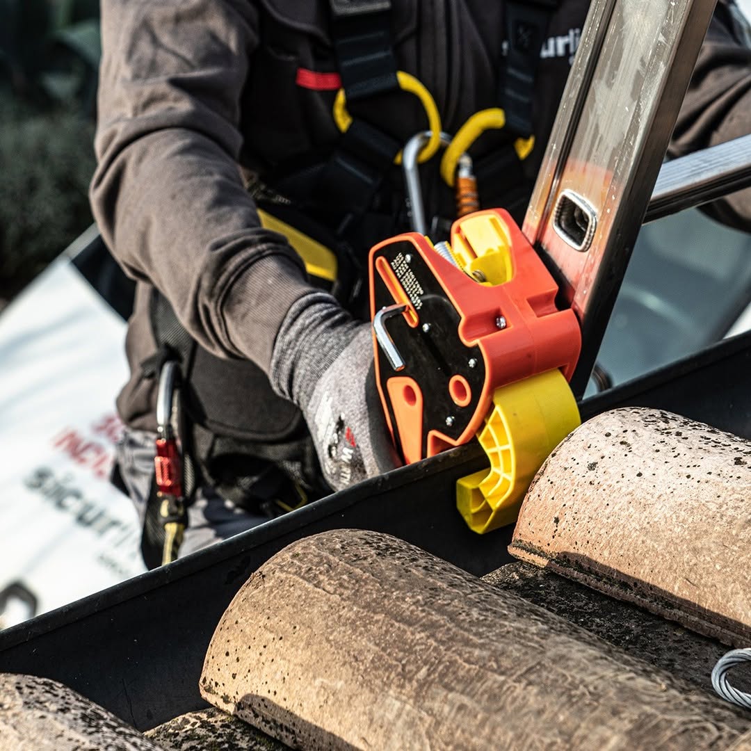 Worker securing ladder with Lock Jaw Ladder Grip for safe rooftop access and stability.