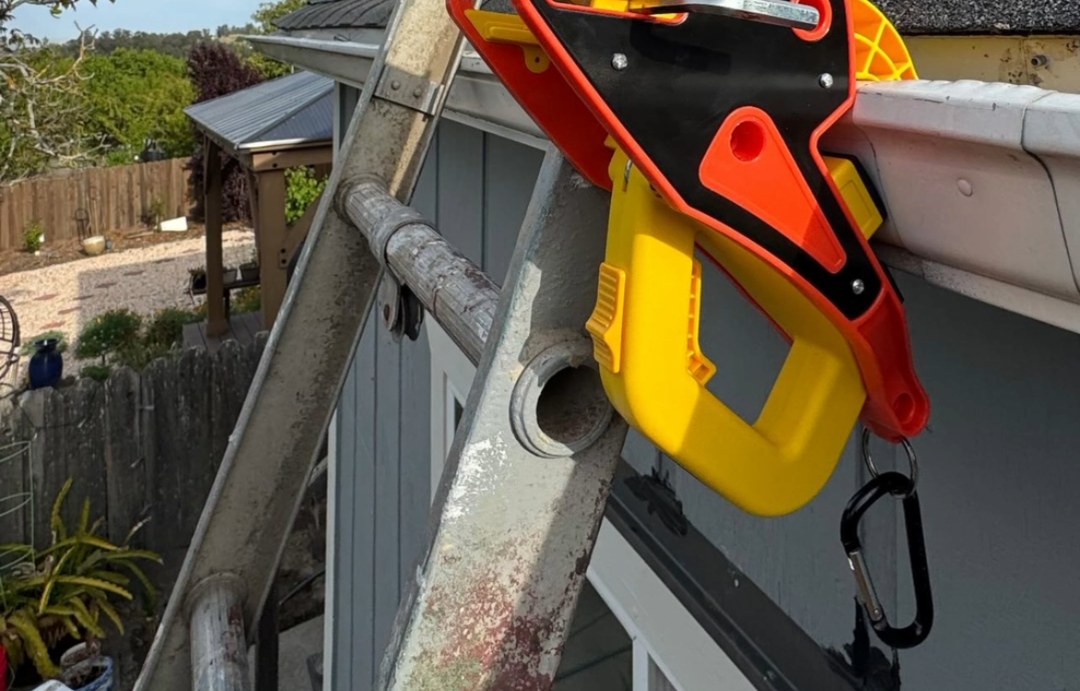 A Lock Jaw Ladder Grip clamped to a gutter with the ladder rail locked in place