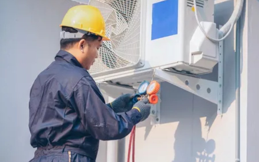 HVAC technician servicing a split system at a house