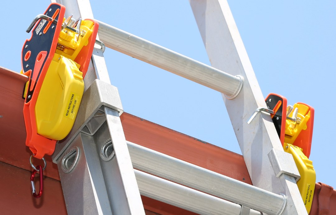 Two Lock Jaw Ladder Grips securing an extension ladder to the gutter