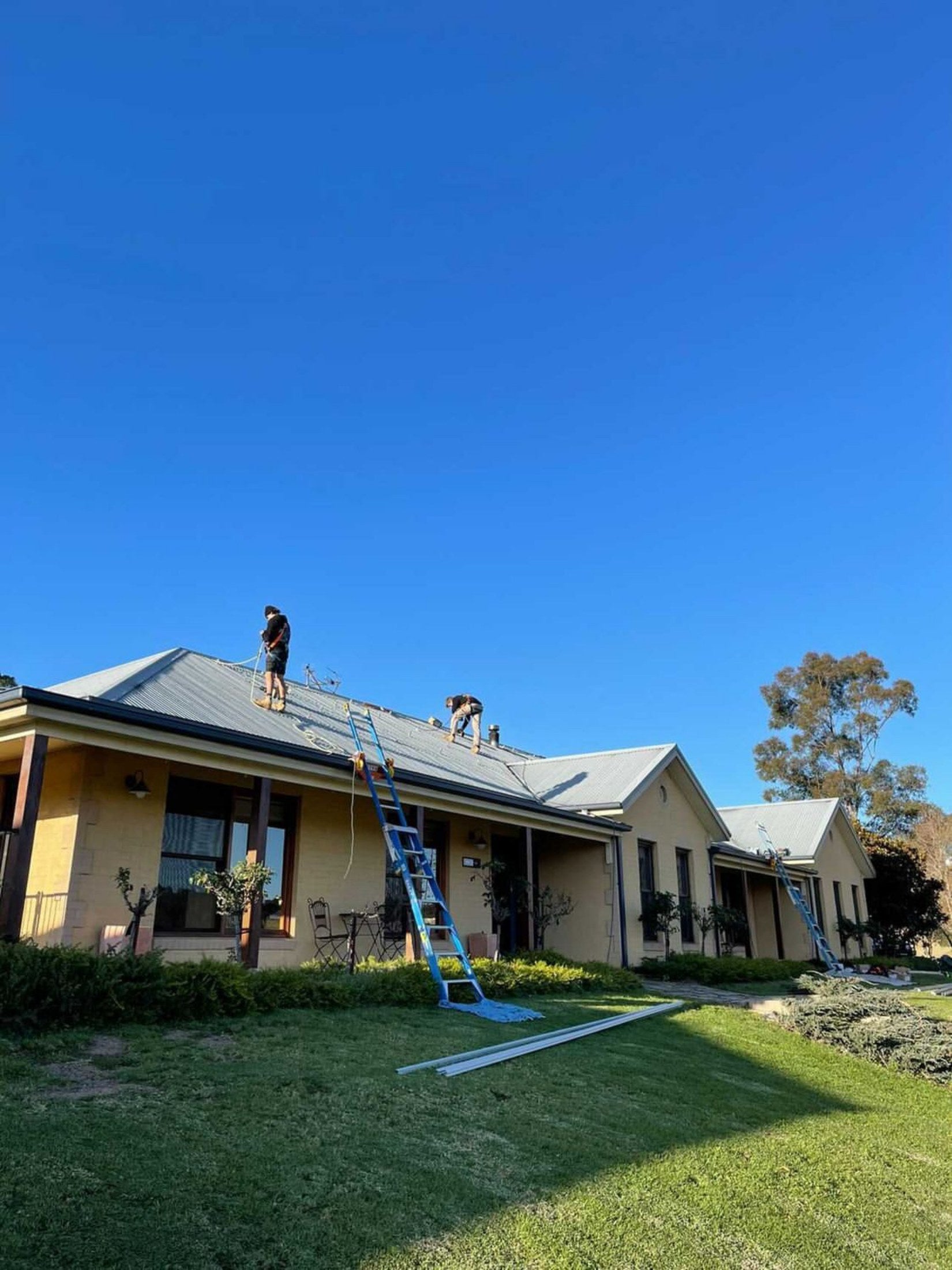 Extension ladder secured to a residential gutter with two Lock Jaw Ladder Grips