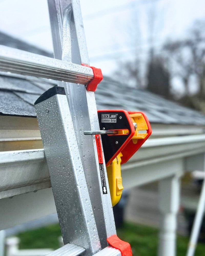 Lock Jaw Ladder Grip clamped between an extension ladder rail and a rain gutter