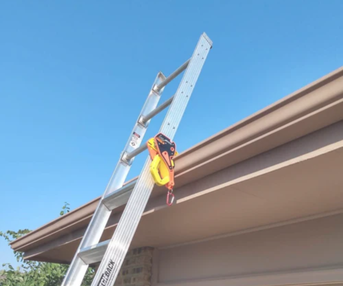 Ladder secured to gutter with Lock Jaw clamp, safe roofing work, clear blue sky, home maintenance.