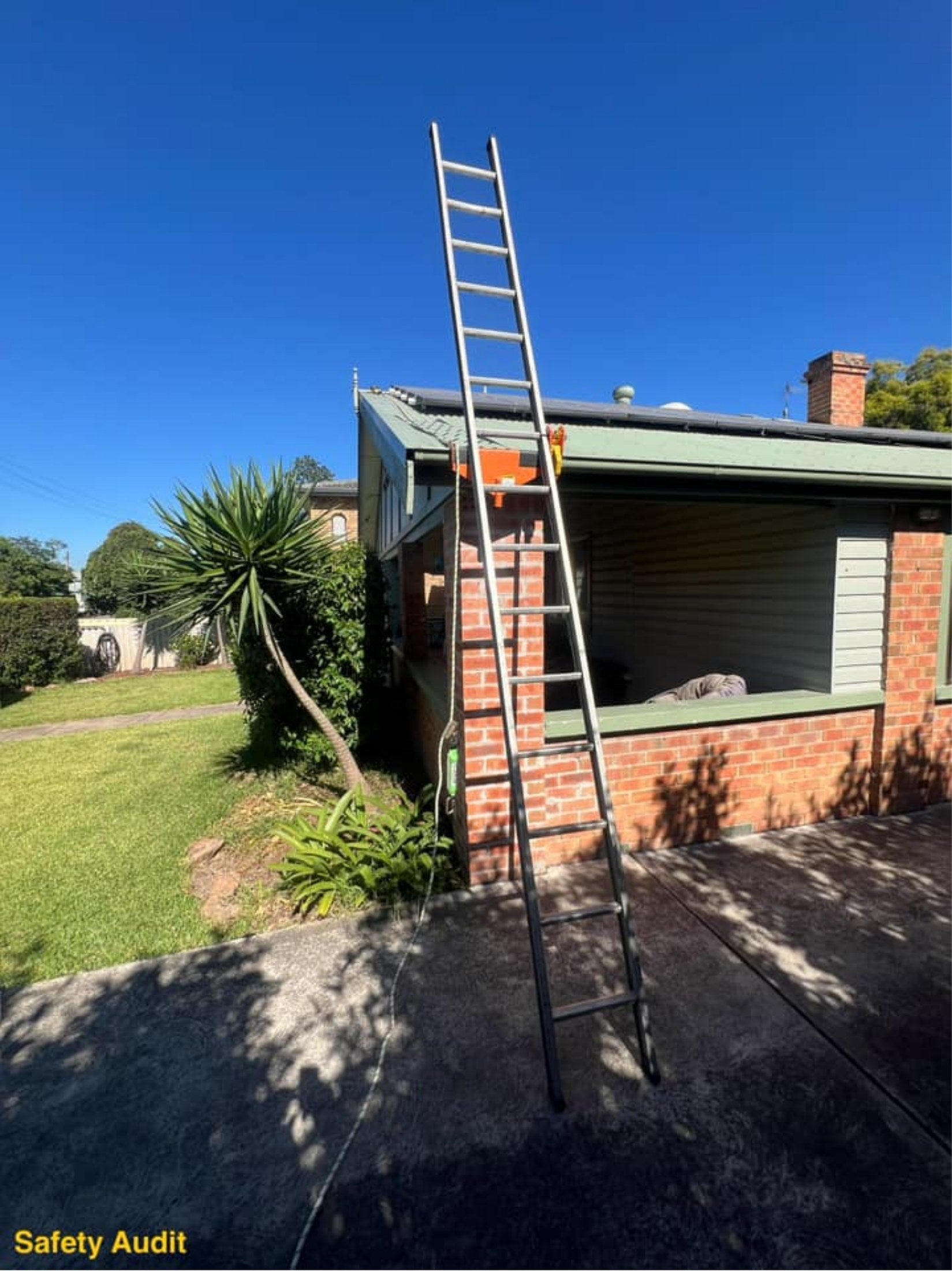 Extension ladder secured to a residential gutter with two Lock Jaw Ladder Grips