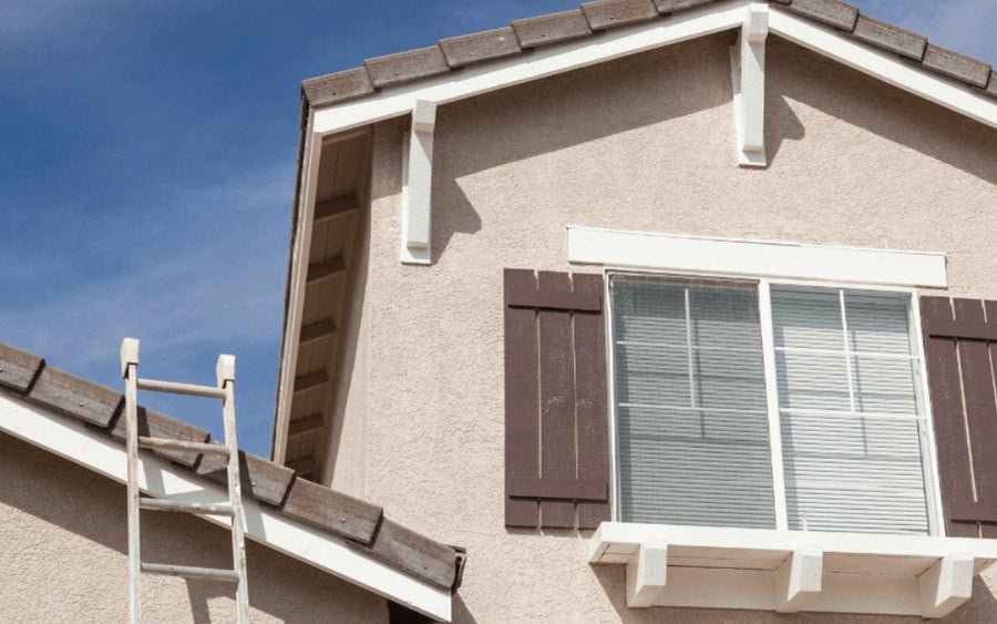 Extension ladder set against the gutter of a gable roofline
